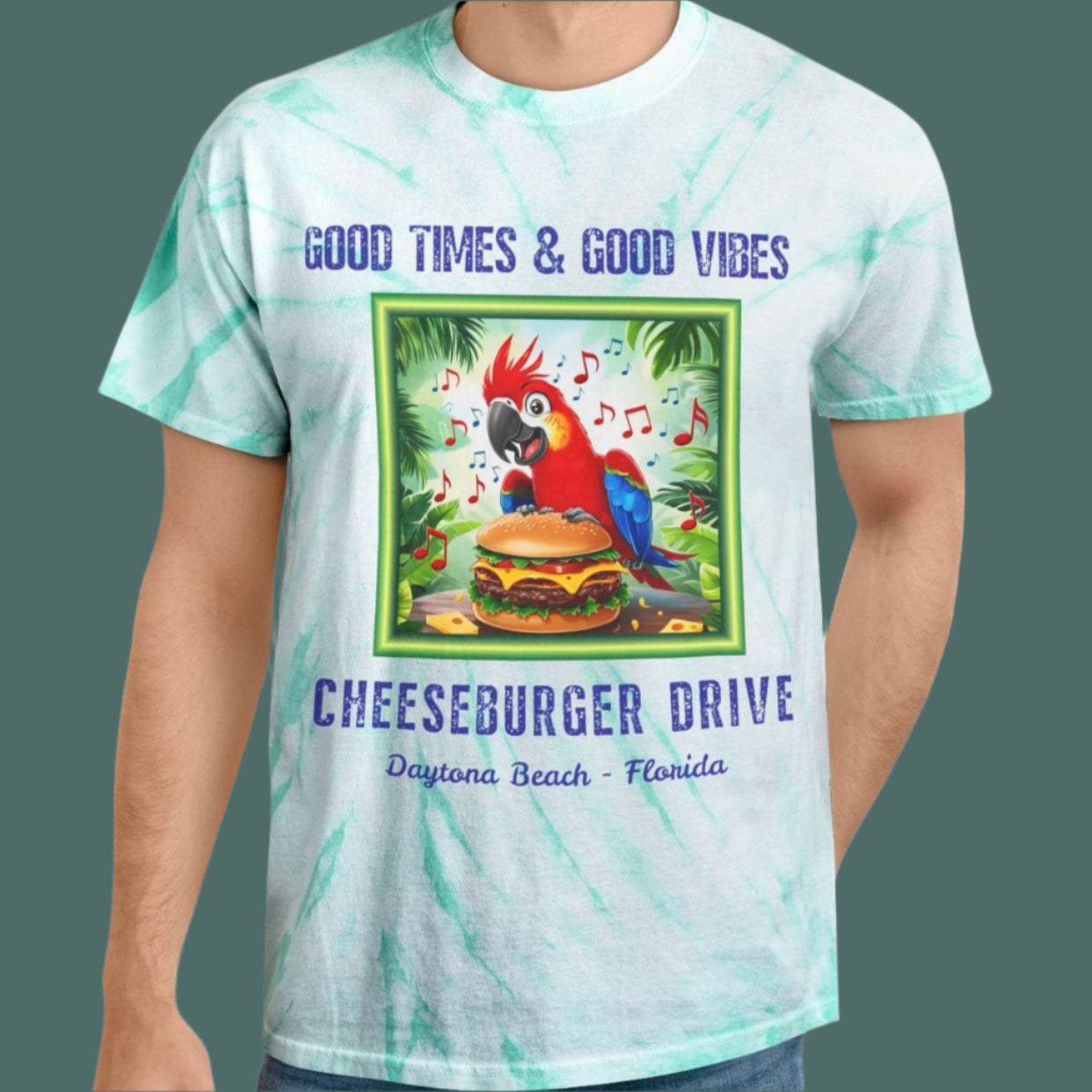Man wearing a tie-dye t-shirt with a graphic of a parrot and cheeseburger, text 'Good Times & Good Vibes' and 'Cheeseburger Drive'.