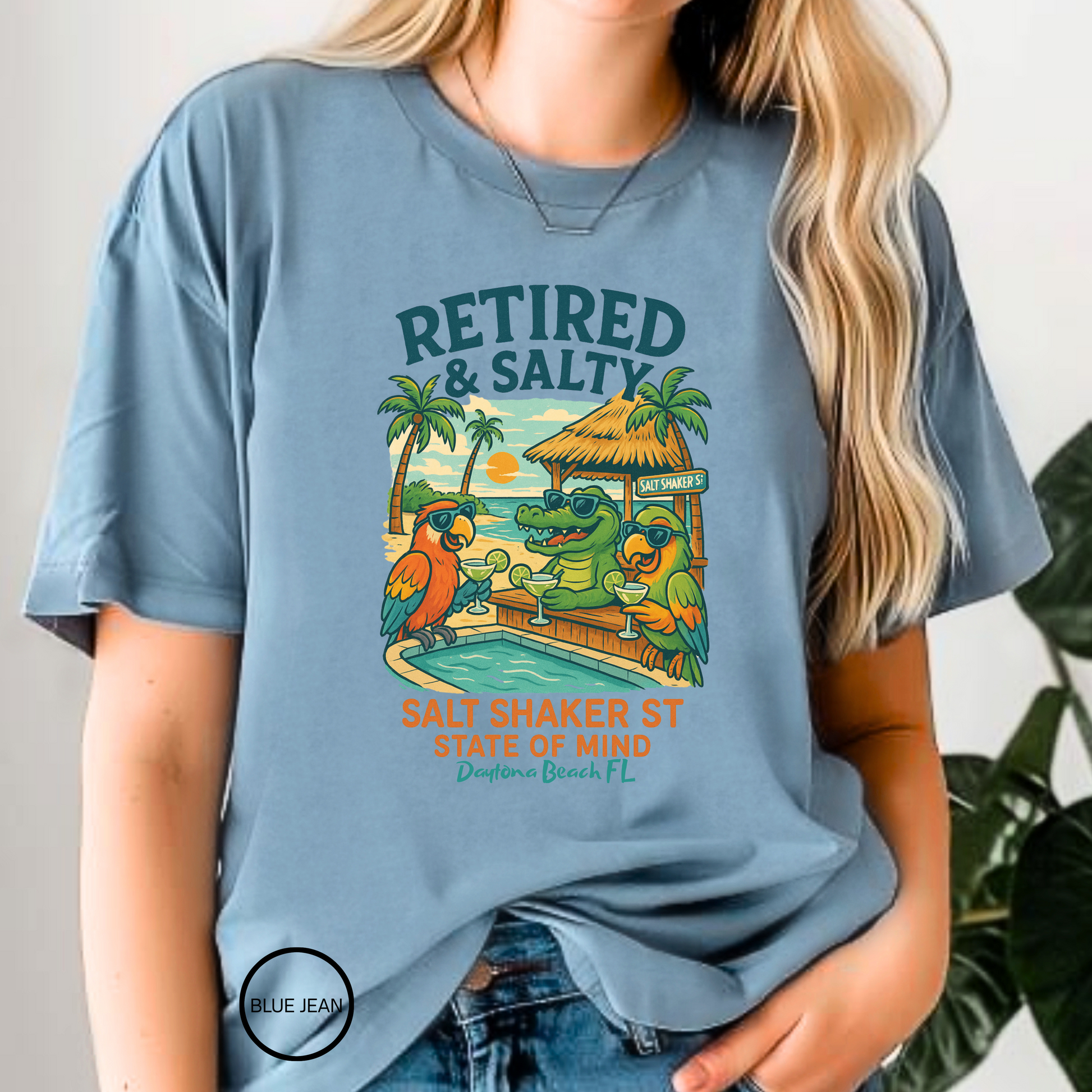 Person wearing a blue t-shirt with a tropical graphic and text.