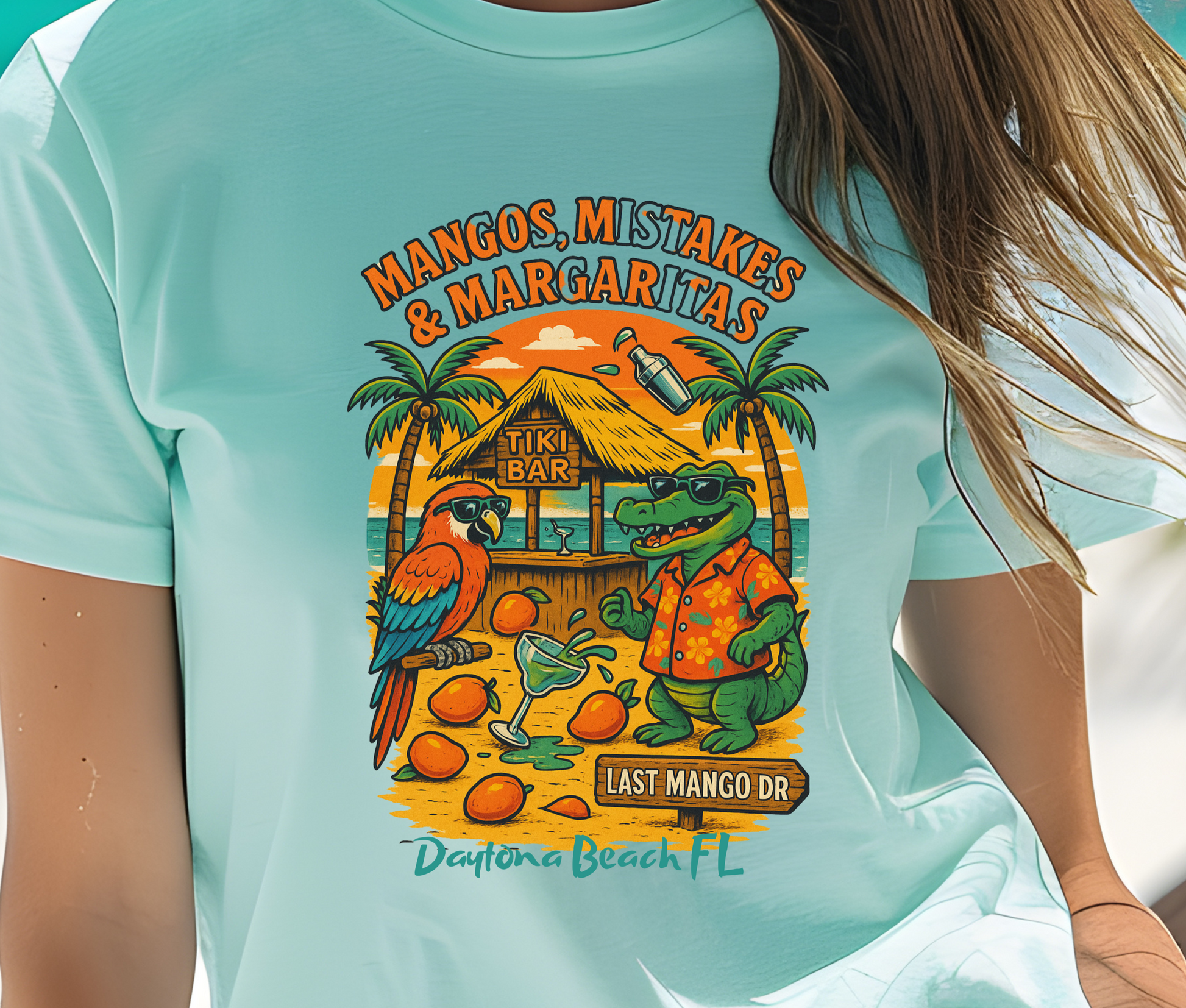 Person wearing a light blue t-shirt with a tropical design and text.