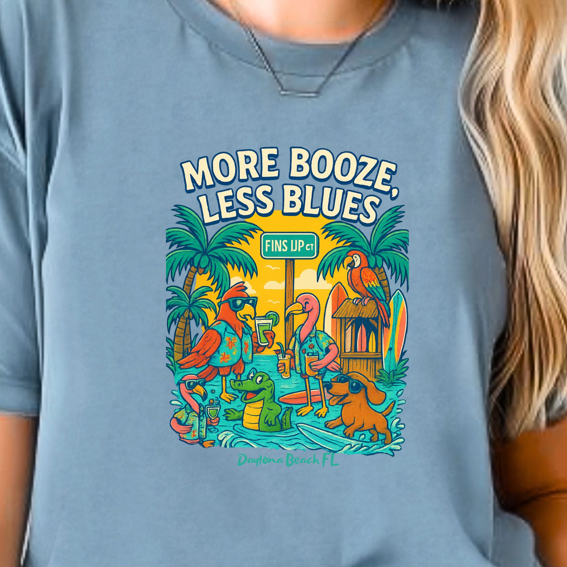 Person wearing a blue t-shirt with a tropical graphic and text.