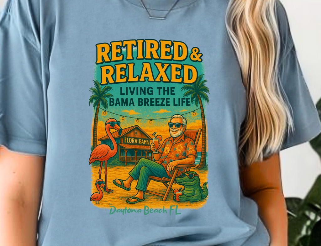 Person wearing a blue t-shirt with a graphic design and text 'Retired & Relaxed Living the Bama Breeze Life'.