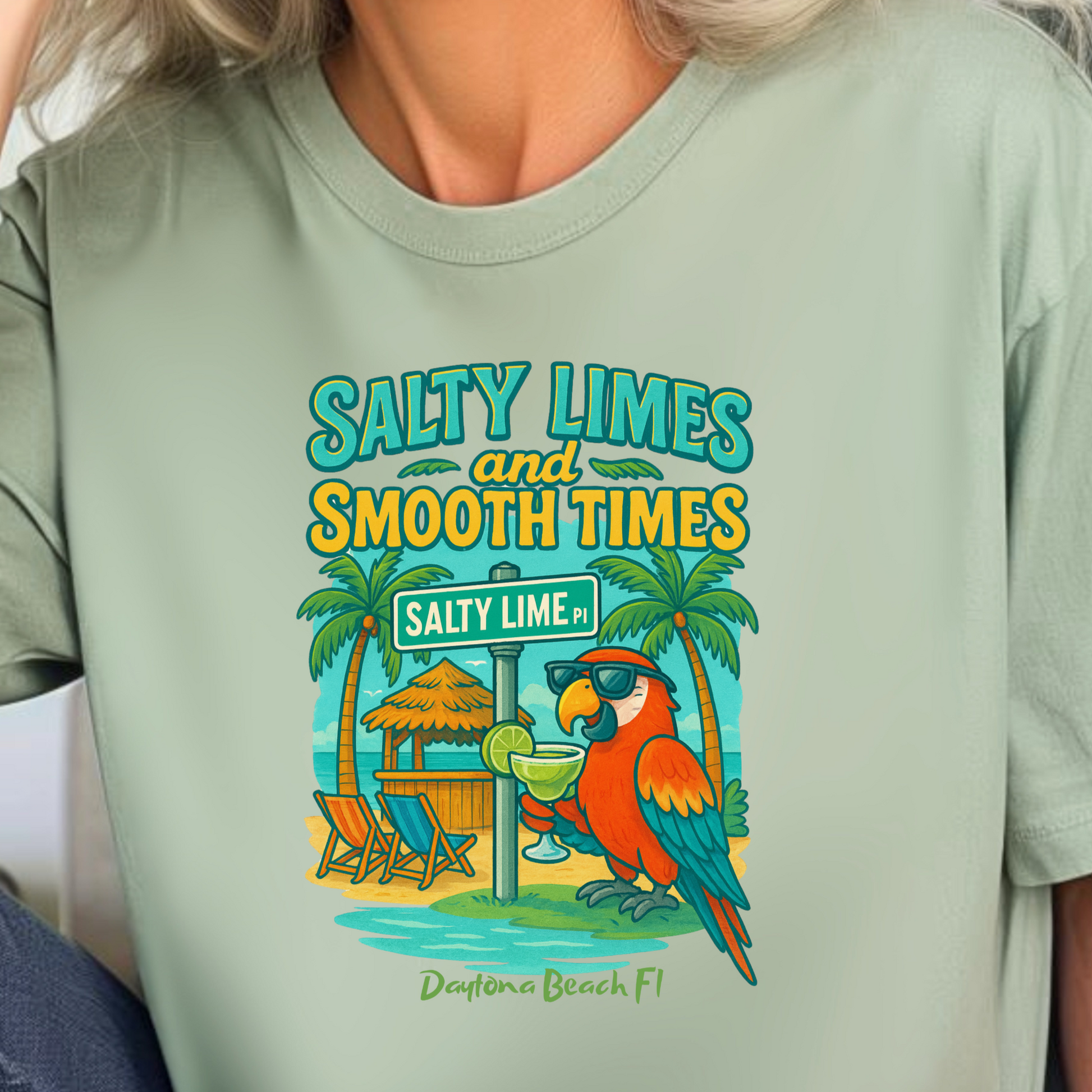 Person wearing a light green t-shirt with a tropical design and text.